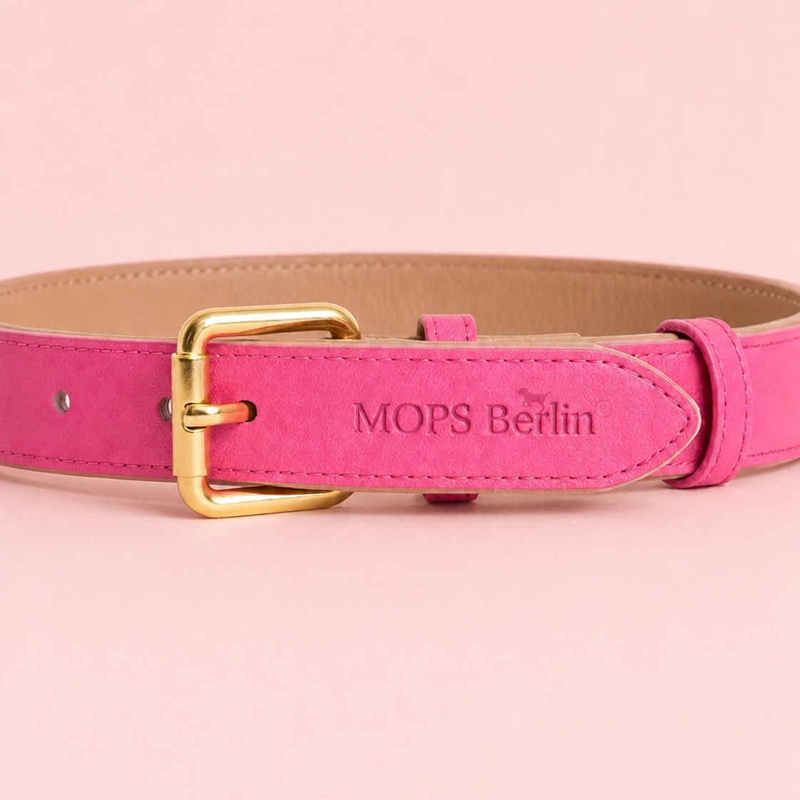Nahaufnahme der goldglänzenden Schnalle und der eingeprägten Markenlogos MOPS Berlin auf dem pinken veganen Lederhalsband Bonbon Glück.