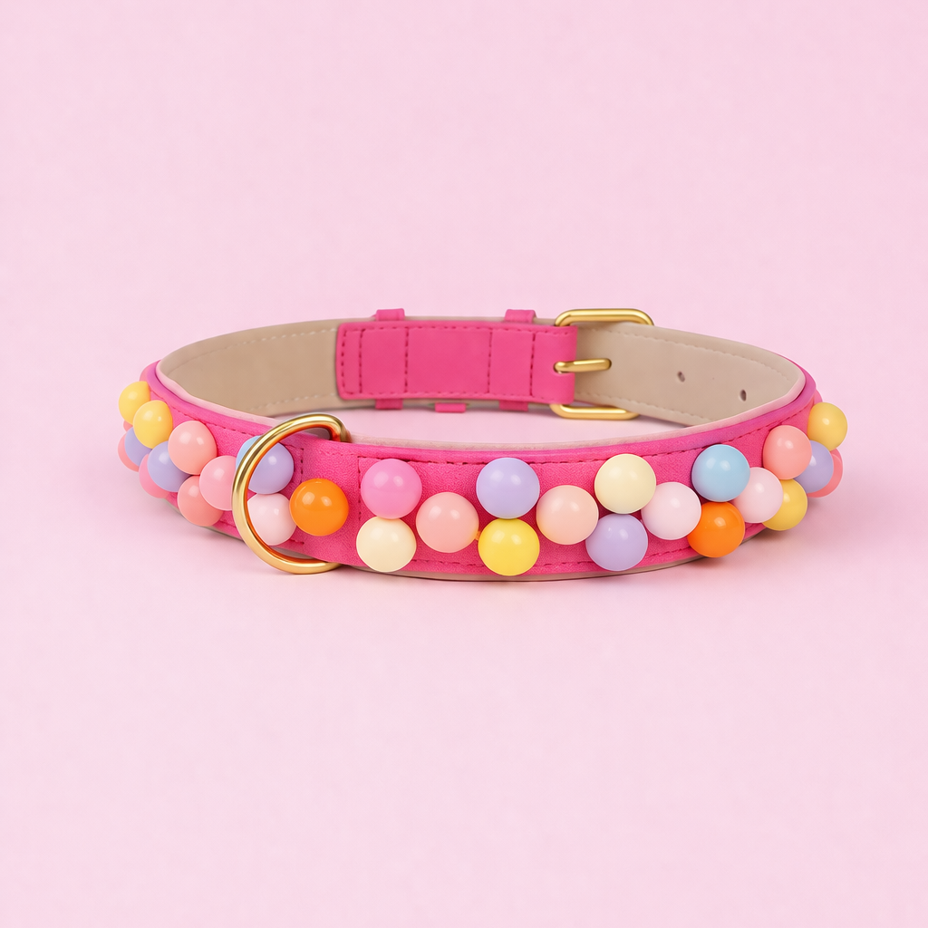 Handgefertigtes Hundehalsband Bonbon Glück aus pinkem veganen Leder mit bunten Perlen und goldener Schnalle von Mops Berlin auf rosa Hintergrund.
