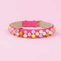 Handgefertigtes Hundehalsband Bonbon Glück aus pinkem veganen Leder mit bunten Perlen und goldener Schnalle von Mops Berlin auf rosa Hintergrund.