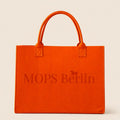 Orangefarbene Filztasche von MOPS Berlin mit eingeprägtem Logo und Tragegriffen vor hellem Hintergrund