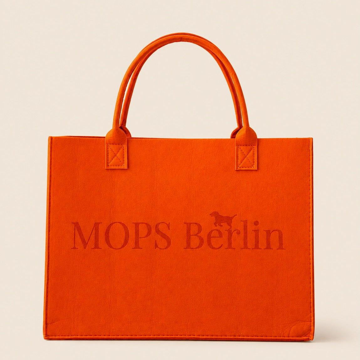 Orangefarbene Filztasche von MOPS Berlin mit eingeprägtem Logo und Tragegriffen vor hellem Hintergrund