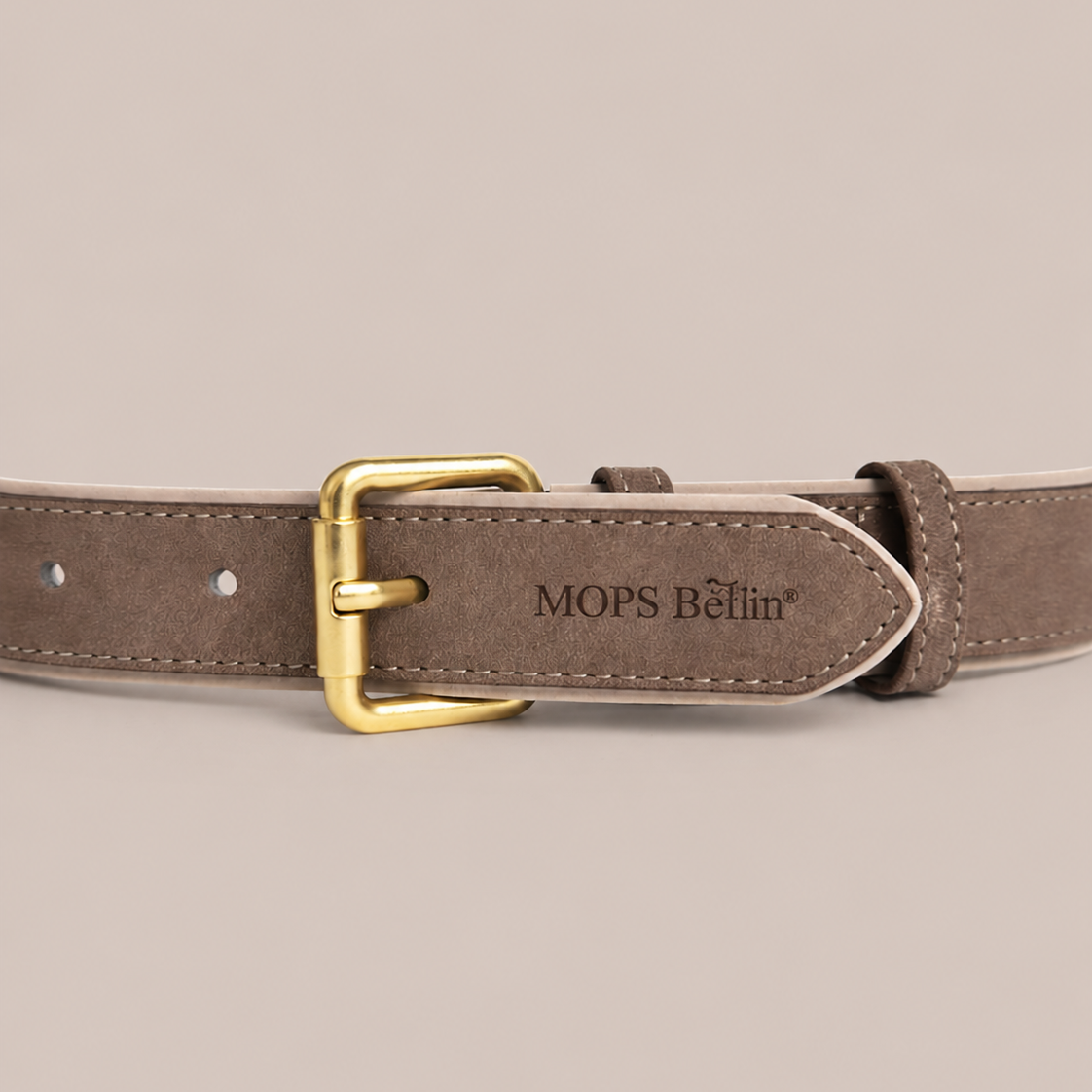 Nahaufnahme vom Schnallenende des Mops Berlin Hundehalsbands aus braunem veganem Leder mit eingeprägtem Markenlogo und mattgoldener Metallschließe